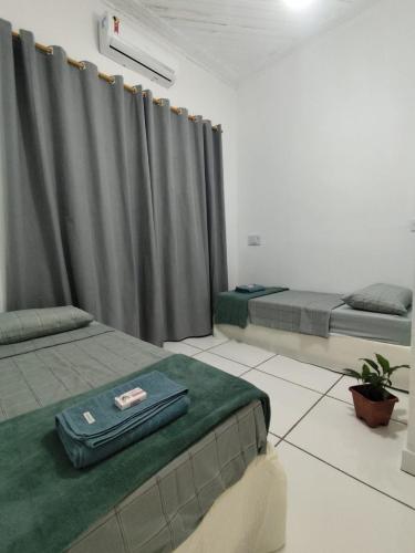 a room with two beds and a curtain at Quarto Privativo com ar condicionado no centro in Ribeirão Preto