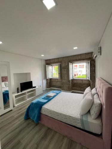 a large bedroom with a large bed and a flat screen tv at Casa Augusta 6 in Braga
