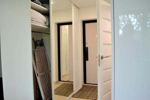 a door leading into a closet with a mirror at Žemaičių g apartamentai in Kretinga