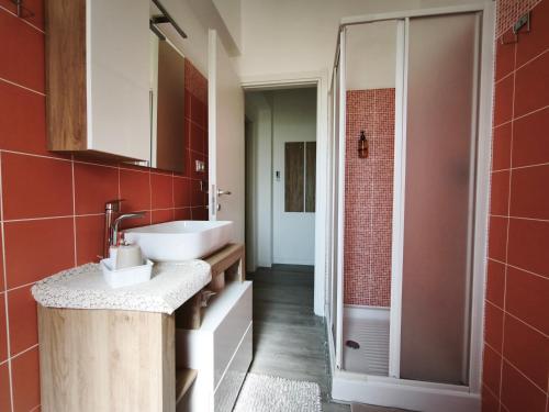 a bathroom with a white sink and red tiles at La Casina di Orsolina - Check-in Flessibile in Livorno