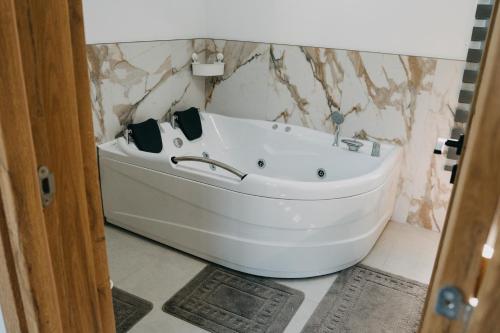 a white bath tub sitting in a bathroom at Nordic Cabin in Bughea de Jos