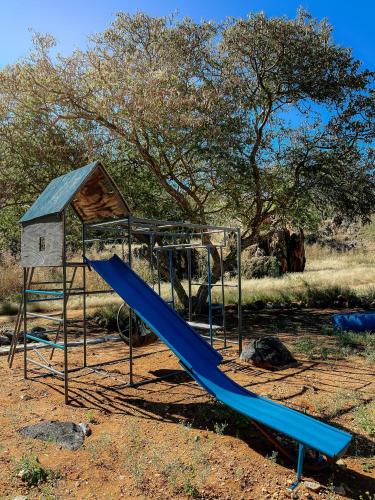 a playground with a slide and a house at Glocke Mountain Camp in Outjo