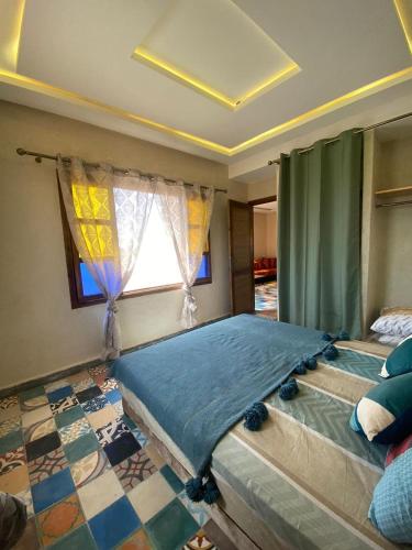a large bed in a room with a window at Le domaine de Koujane in Oulad el Guern
