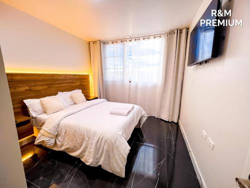 a small bedroom with a bed and a television at Hospedaje R&M in Pelileo
