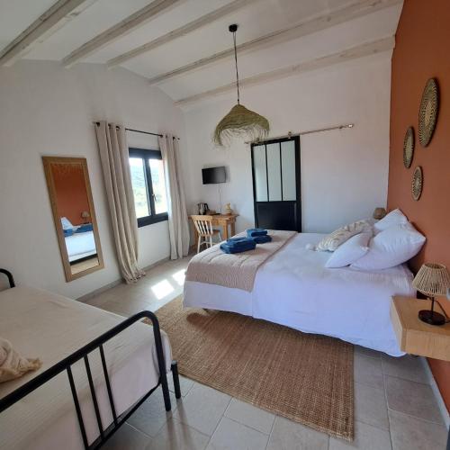 a large bedroom with two beds and a table at Mas del Sola in Castelnou