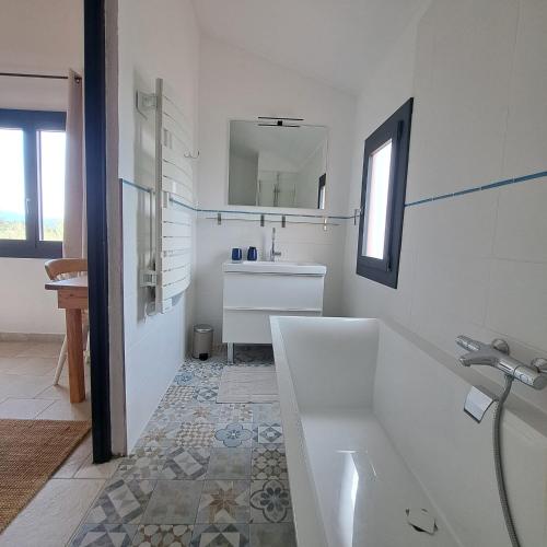 a white bathroom with a tub and a sink at Mas del Sola in Castelnou