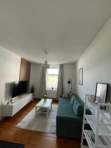 a living room with a green couch and a table at Cityapartment Rosi in Pasewalk