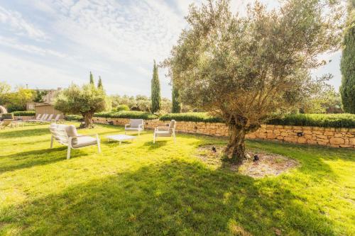 an apple tree in a yard with chairs and a table at New to the market - 4BR Farmhouse with Pool by SF Homes in Siġġiewi