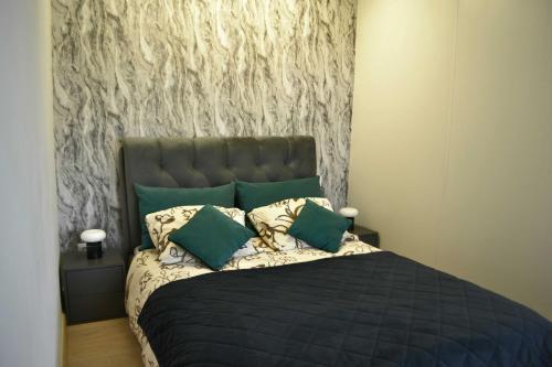 a bedroom with a large bed with green pillows at Žemaičių g apartamentai in Kretinga