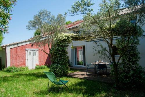 a house with a table and chairs in the yard at Les Airis, maison de vacances écologique in Avignon