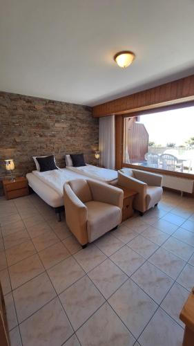 a large bedroom with a bed and a couch at Centre Thermal - Studio SUD avec grande terrasse in Ovronnaz