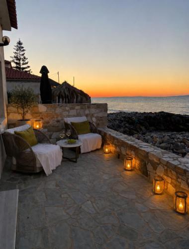 a patio with beds and lights and the ocean at Villa Harmonia II-Seafront Retreat in Livadáki