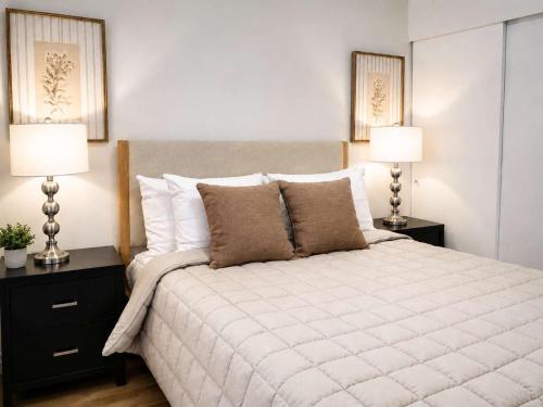 a bedroom with a large white bed with two lamps at Bellevue Pet friendly Home Fenced Yard in Bellevue