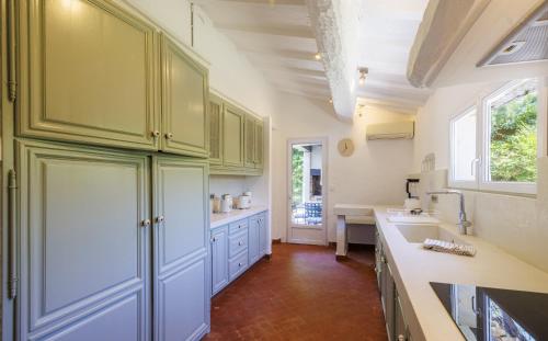 a large kitchen with green cabinets and a sink at villa la Sine in Vence