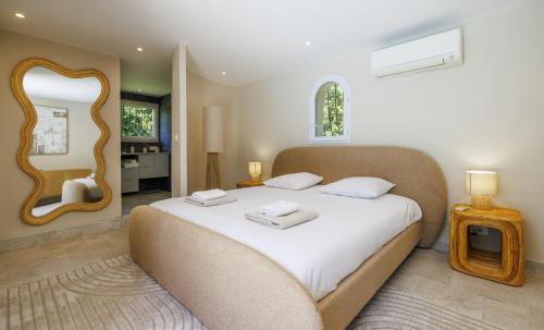 a bedroom with a large bed and a mirror at villa la Sine in Vence