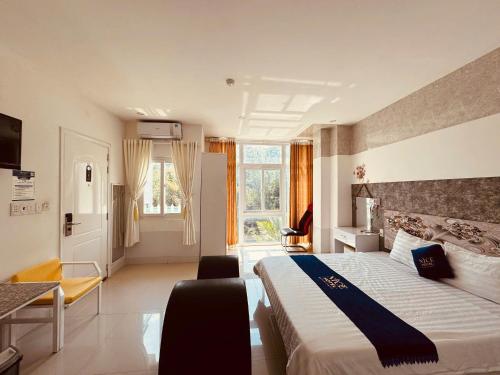 a hotel room with a bed and a desk at Nice Hotel Buôn Ma Thuột in Buon Ma Thuot