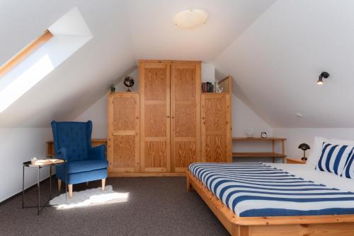 a bedroom with a bed and a blue chair at Captain's Quarters - with Terrace and Parking near Lake Balaton in Keszthely