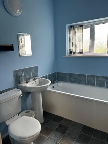 a bathroom with a toilet and a sink and a bath tub at Bungalow 19 Widemouth Bay in Poundstock