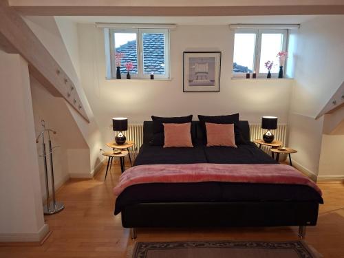 a bedroom with a large bed with two windows at Rosarote Insel - La Vie en Rose in Lindau