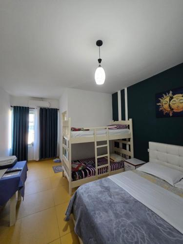 a bedroom with two bunk beds and a couch at Hotel Restorant Genti Peshkatari in Orikum