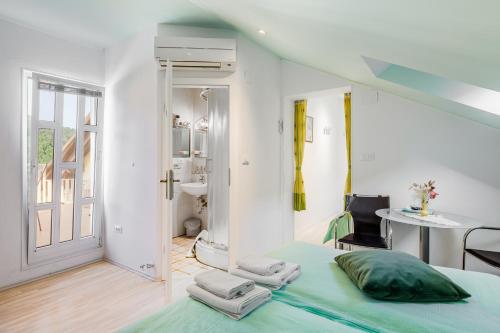 a bedroom with a green bed and a bathroom at Guesthouse Sobe Silva in Tolmin