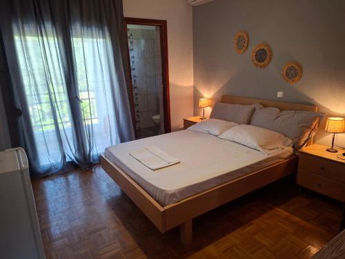 a bedroom with a bed with two lamps and two windows at Villa Rodia in Potos
