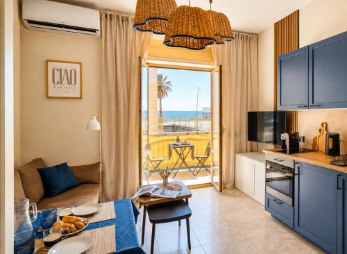 a living room with a table and a kitchen with a view at Oceanine 7 - Seaview Apartment in Lido di Ostia