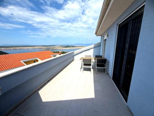 a balcony with a table and chairs on a building at Anai Jadranovo Sea View Penthouse in Jadranovo