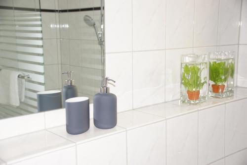 uma casa de banho com dispensadores de sabão azuis e um espelho em Hotel Jägerhof em Ratingen
