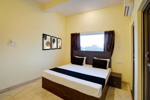 a bedroom with a large bed with a window at Hotel O Maa JP Tower in Jabalpur