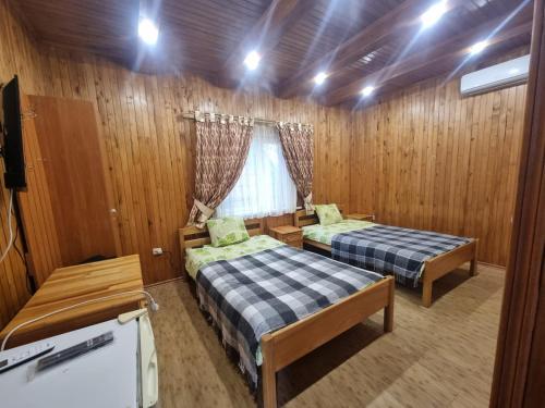 two beds in a room with wood paneling at Бухта Вікінга in Szack