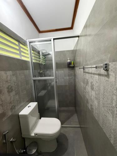 a bathroom with a toilet and a glass shower at Lobo's Retreat in Kurunegala