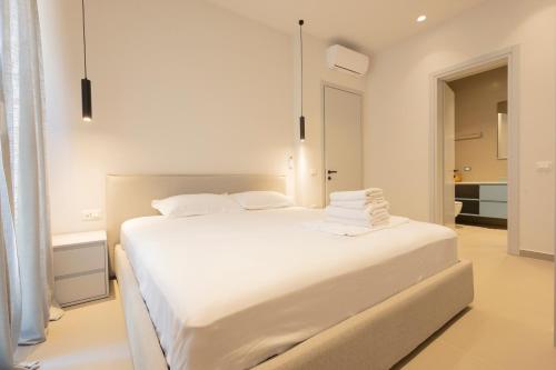 a bedroom with a white bed with towels on it at Aria apartment 2 in Dhërmi