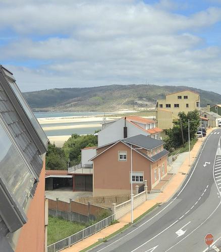 a view of a street with a building and a beach at Mar de Laxe Vistas al mar y Costa da Morte in Cabana de Bergantiños