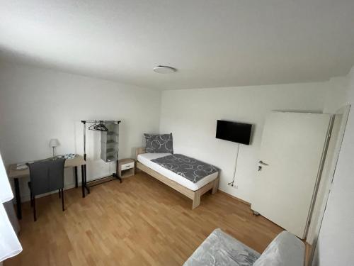 a bedroom with a bed and a desk and a tv at GrafOne Apartment in Waizenkirchen