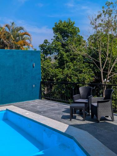 a patio with chairs and a swimming pool at Céntrica habitación 2 camas queen - Gran Nehtolli #7 - Sin Estacionamiento in Xilitla