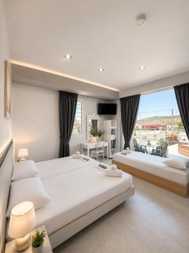 two beds in a bedroom with a large window at Nova marine 5 in Souda