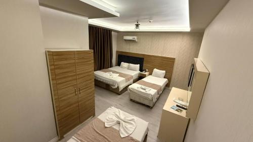 a small hotel room with two beds and a mirror at Grand Black Hotel in Mersin