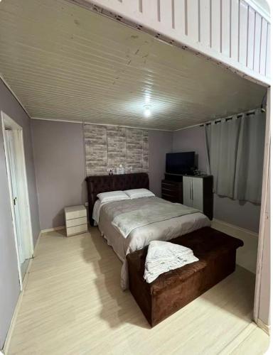 a bedroom with a large bed and a tv at Incantare in São Joaquim