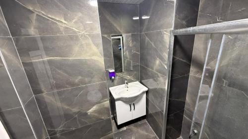 a bathroom with a sink and a mirror at Grand Black Hotel in Mersin