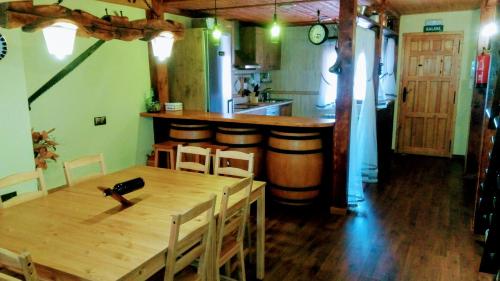a dining room with a wooden table and a kitchen at El Pozo de la Cotarra in Cabezuela