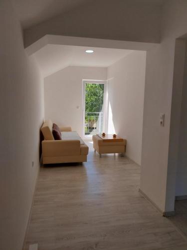 a living room with a couch and a window at Apartmani Lohovo 2 in Lohovo