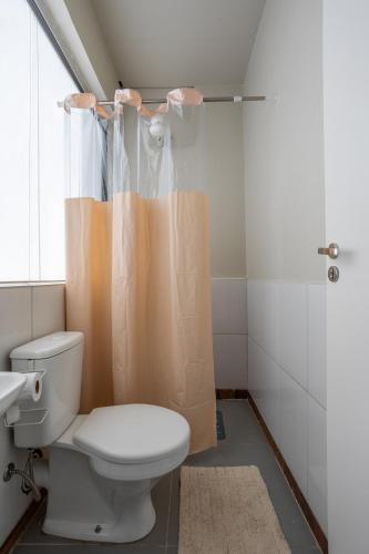a bathroom with a toilet and a shower curtain at APT 302 - 5 min do aeroporto com ar-condicionado, rodoviária e embaixadas in Brasília