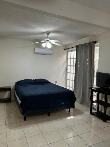 a bedroom with a bed and a ceiling fan at Comfortable house with an excellent location in Veracruz