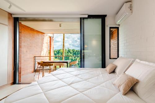 a bedroom with a bed and a balcony with a table at Selva Vista in Pereira