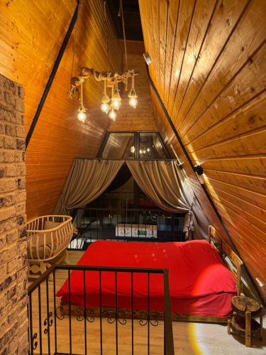 a bedroom with a red bed in a wooden ceiling at Banderabungalov in Kartepe