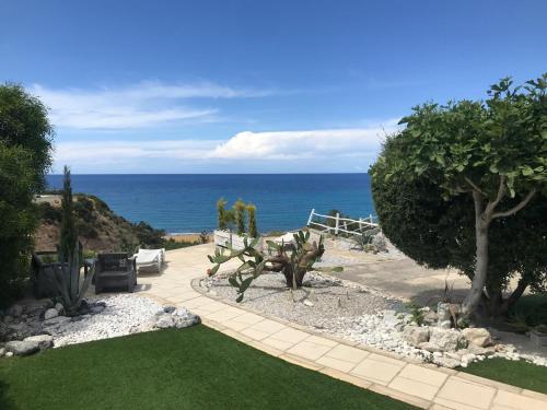a garden with a bench and a view of the ocean at Boutique seafront apartment in Saint Amvrosios