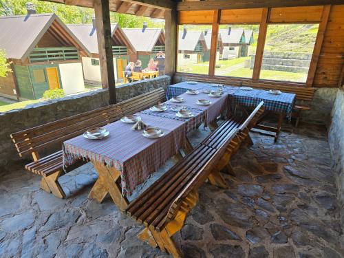 a dining room with a table and benches in a building at Katun Komovi in Andrijevica