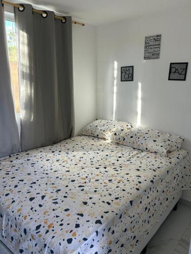 a bed with a comforter and pillows in a bedroom at Flat no Alto de Bezerros Casa 7 in Bezerros