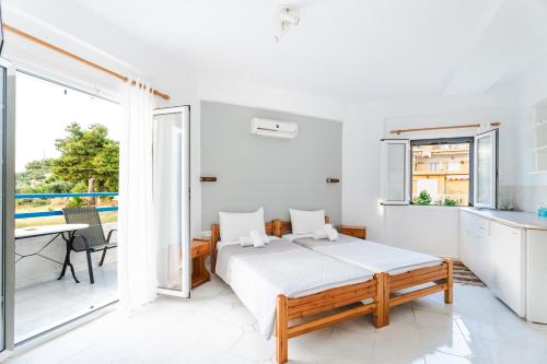 a white bedroom with a bed and a balcony at Fiore Di Mare Studios in Lassi